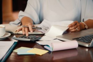 Persona revisa documentos y utiliza una calculadora