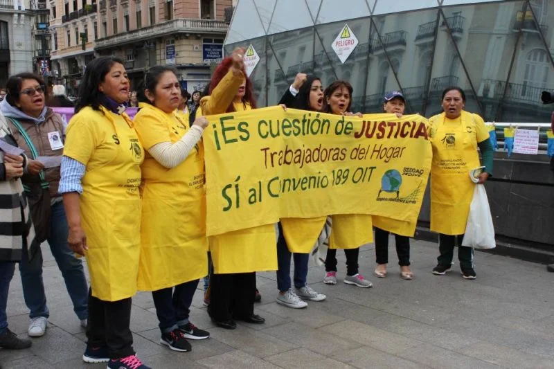 Mujeres se manifiestan con una pancarta sobre derechos laborales