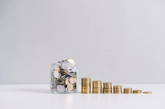 Monedas apiladas y frasco con ahorros