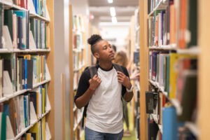 Joven consulta libros en una biblioteca
