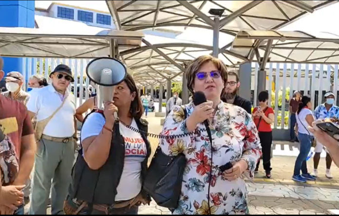 Mujer habla ante medios de comunicación en un espacio exterior