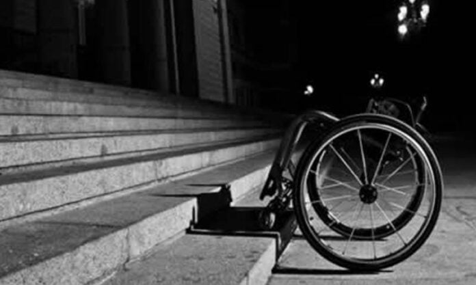 Silla de ruedas vacía junto a unas escaleras