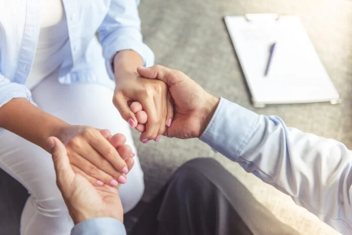 Profesional de la salud sostiene la mano de un paciente