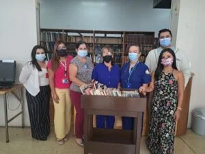 Grupo de personas posa durante una actividad en una biblioteca