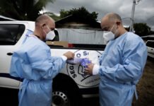 CCSS confirma cambios en atención Paraíso Personal sanitario inspecciona un paquete junto a un vehículo