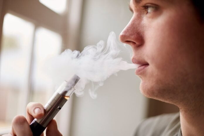 Vapear combinado con fumar, ¿tan dañino como solo fumar cigarrillos? Persona utiliza un cigarrillo electrónico
