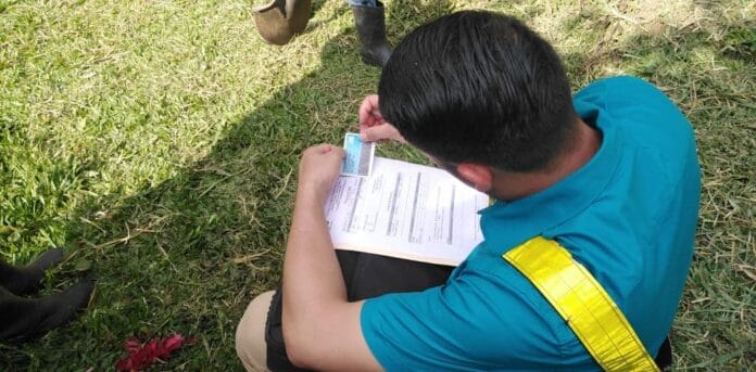 Persona completa un formulario sobre el césped