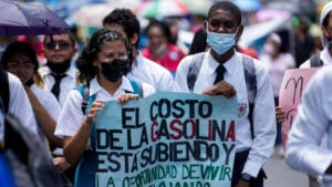 Manifestantes sostienen un cartel sobre el costo de la gasolina