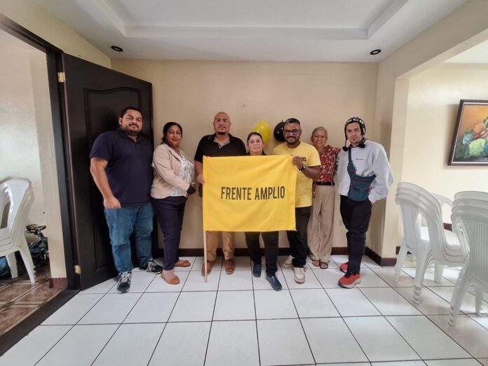 Grupo posa con una bandera del Frente Amplio