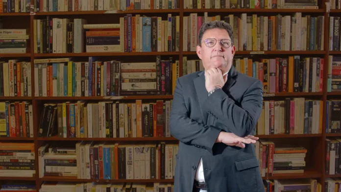 Elliot-Coen-Lanza-Libro-Sobre-Comunicacion-Efectiva-Y-Conexion-Humana Hombre posa frente a una biblioteca